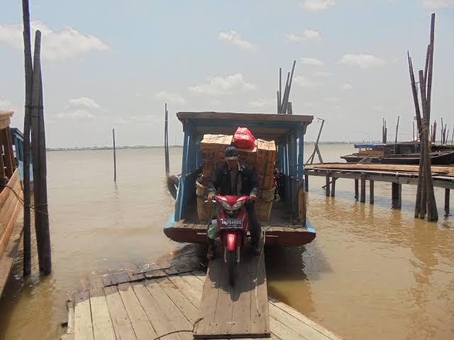 Salah seorang penumpang dengan sepeda motornya turun dari penyeberangan Kempang